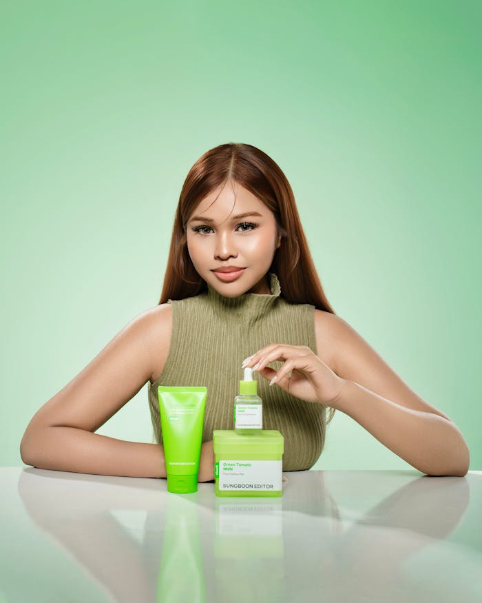 A woman presenting green skincare products in a Phnom Penh studio with a soft green backdrop.